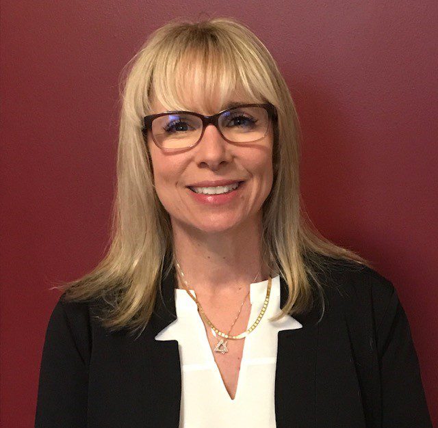 Smiling woman with glasses and blonde hair
